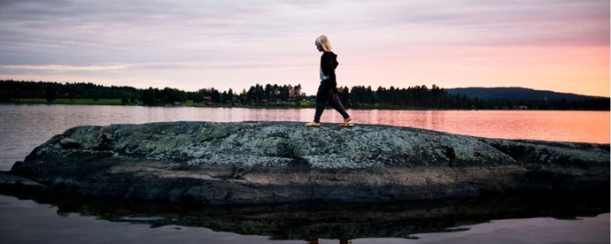 Barn som går på en klippa vid sjön