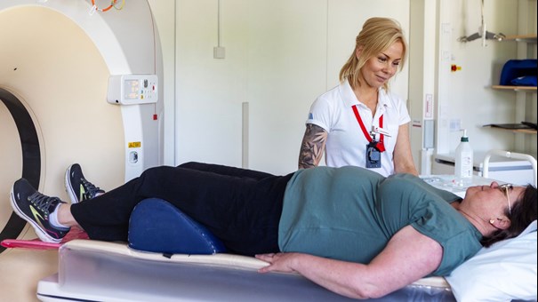 Sjuksköterska och patient vid röntgenmaskin.