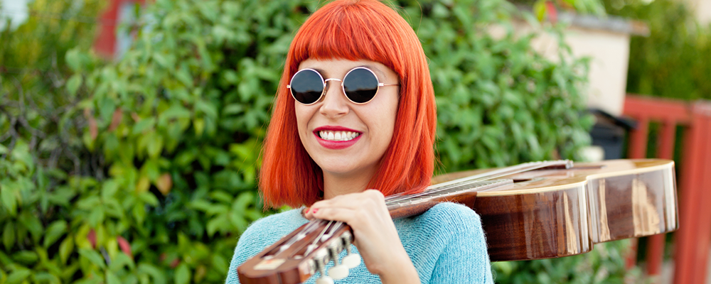 rödhårig kvinna som bär en gitarr