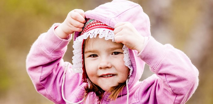 Flicka med huvjacka.